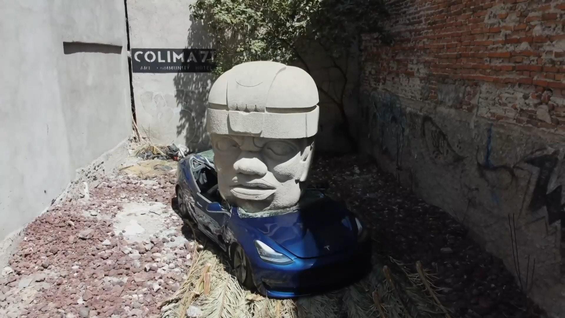 Tesla meets the Stone Age! Mexican artist crushes luxury car with giant ...
